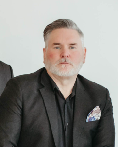 Daryl Hanna professional headshot in black suit, Las Vegas luxury real estate agent